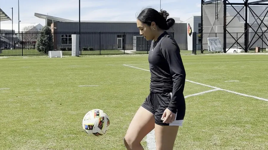 Soccer athlete practicing controlled footwork on a grass field