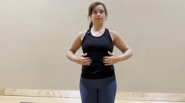 Adult practicing calm breathing with hands resting along the lower ribs