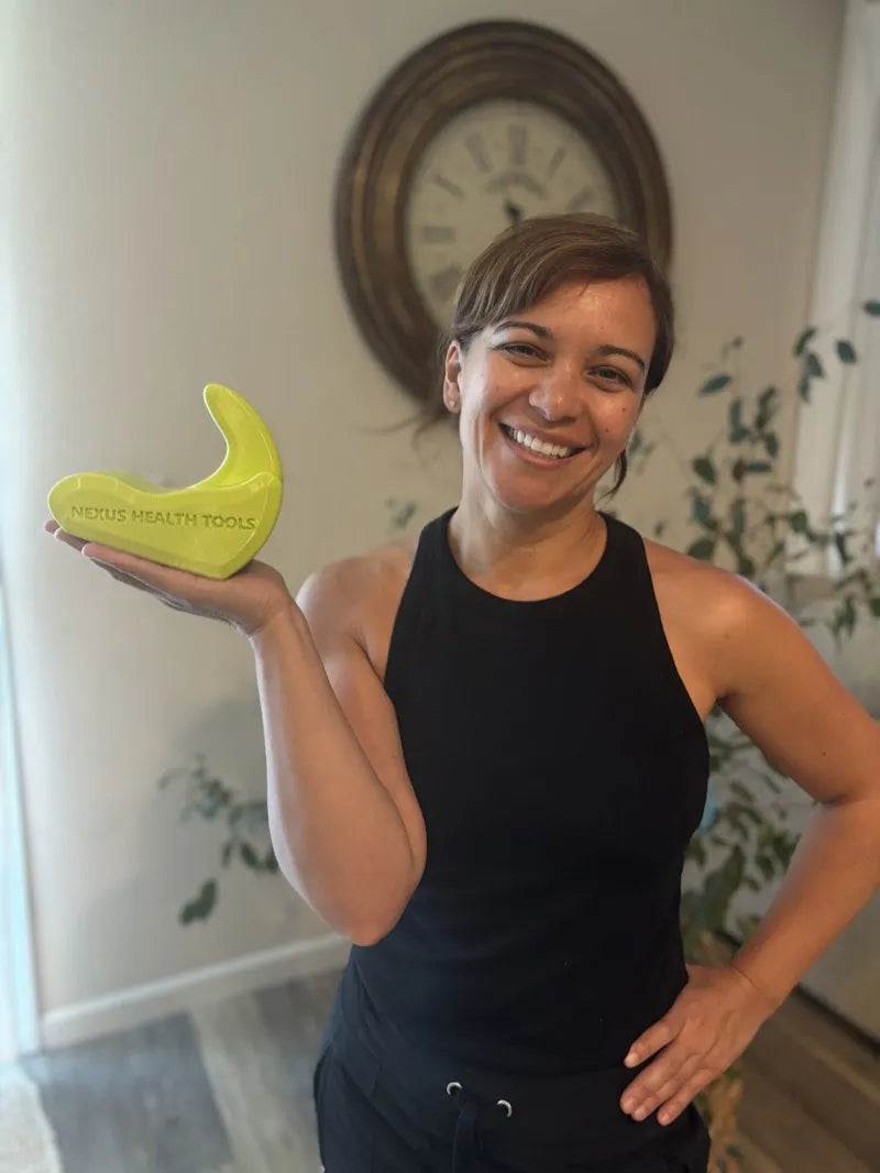 Person holding the Core Nexus dual-tip psoas and iliacus release tool — a professional evaluating what to look for in a psoas release tool