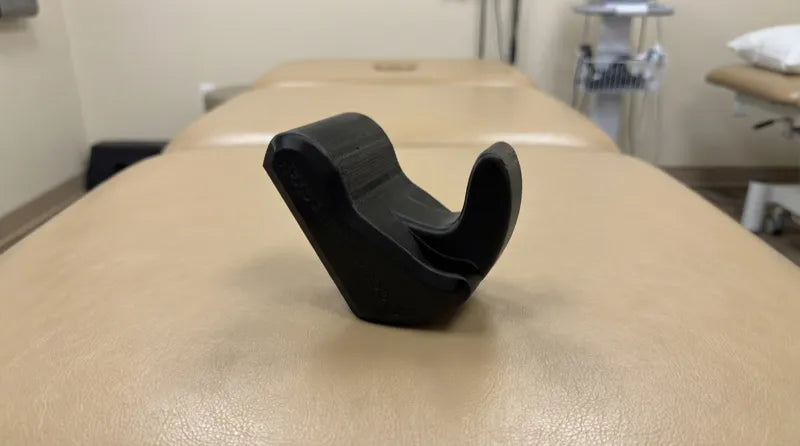 Black Core Nexus release tool on a physical therapy approach table alongside foam roller and resistance bands in a clinical setting